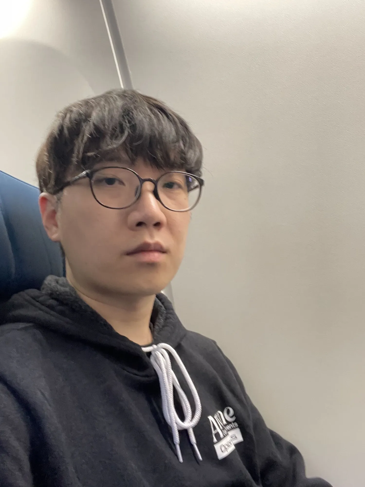 Wesley posing next to his window seat on a Westjet flight that had no windows